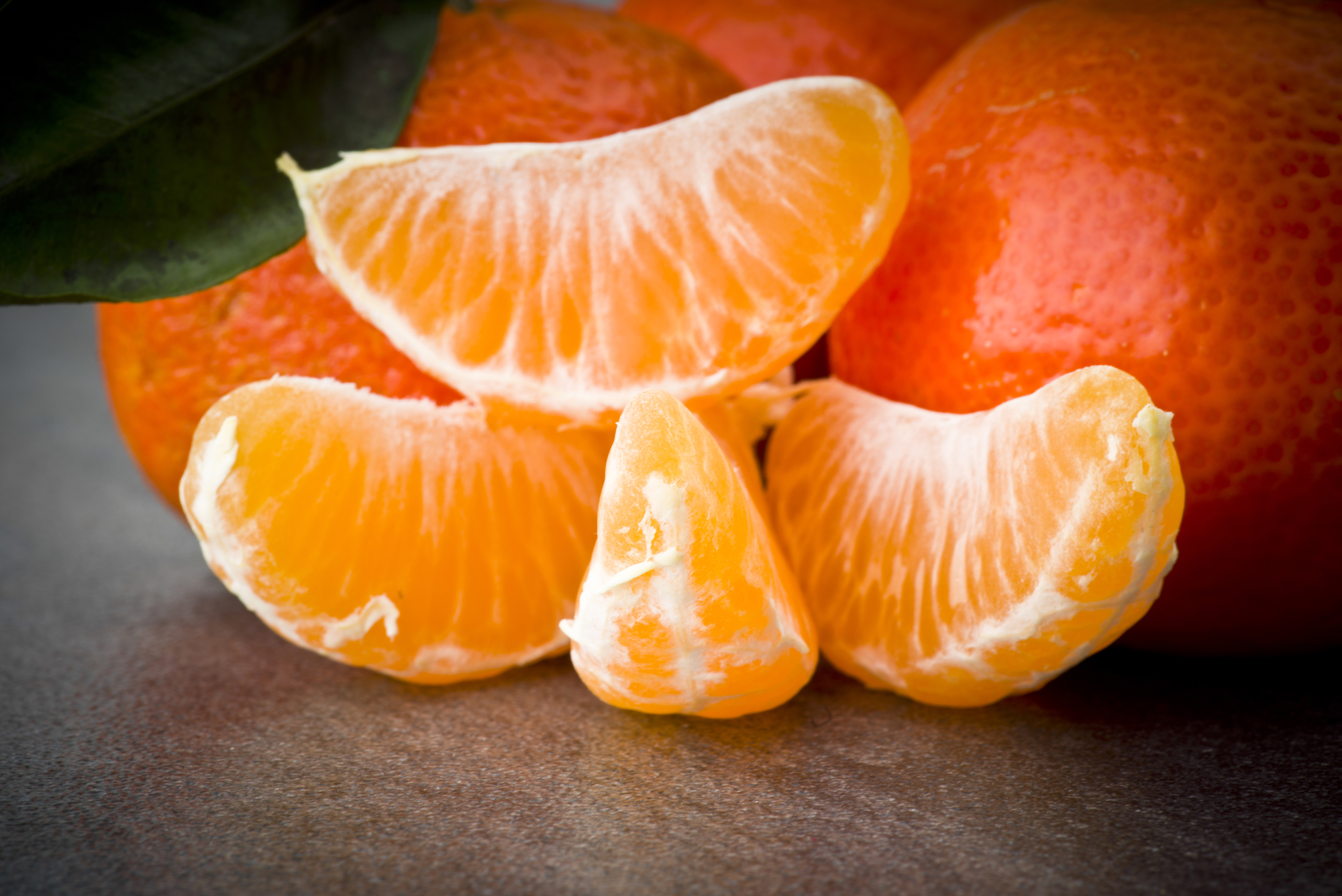 Ripe orange tangerine clove on the gray table